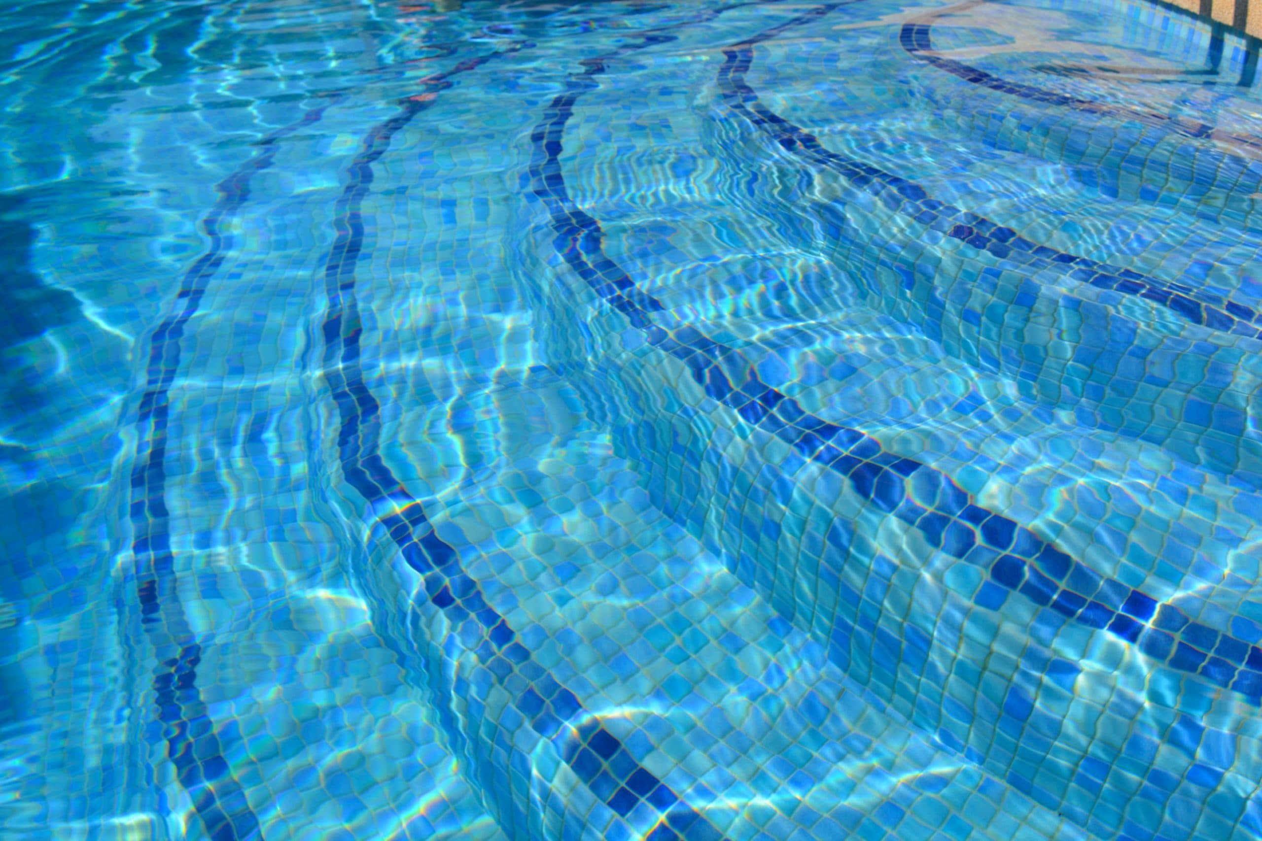 agua cristalina en una piscina de azulejos azules