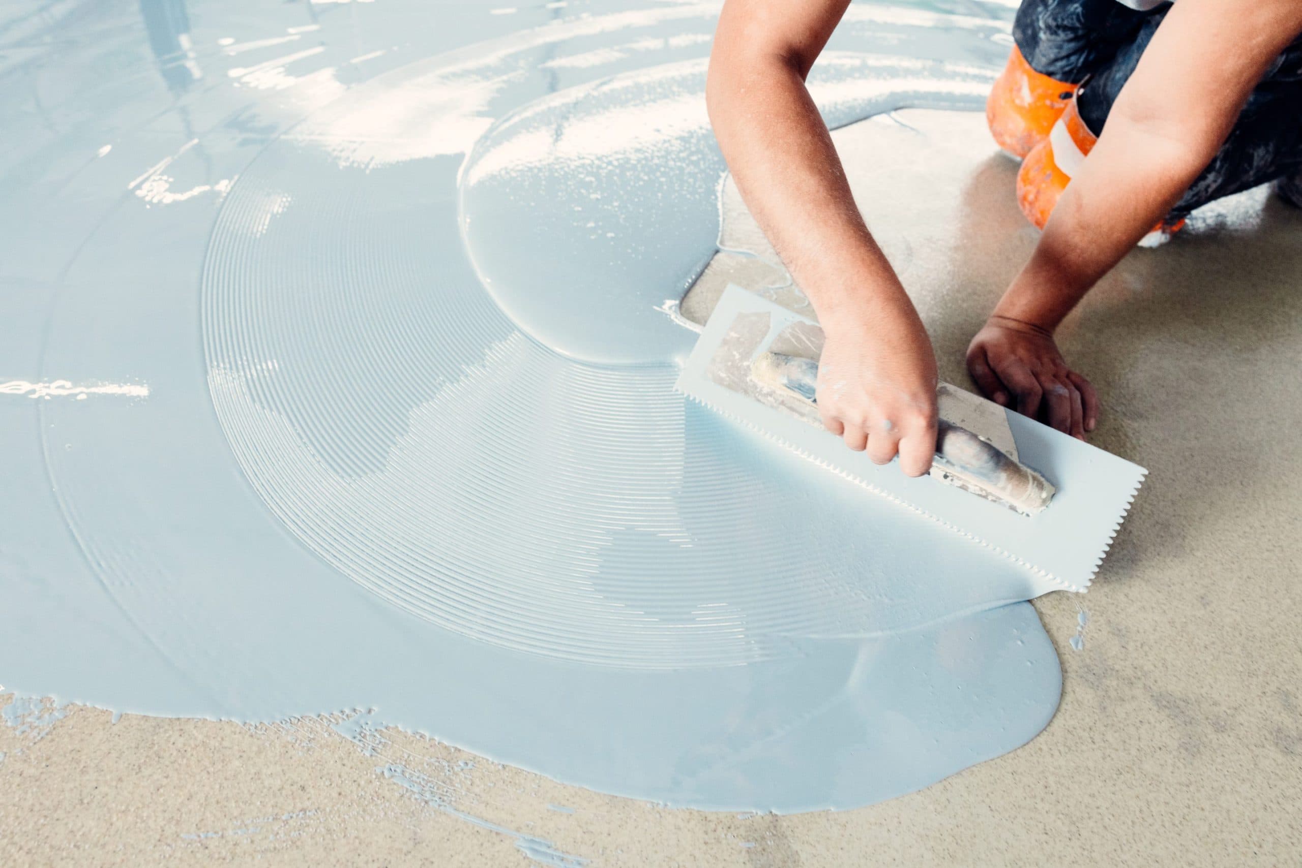 worker applying epoxy to concrete floor 2026 03 18 14 52 25 utc