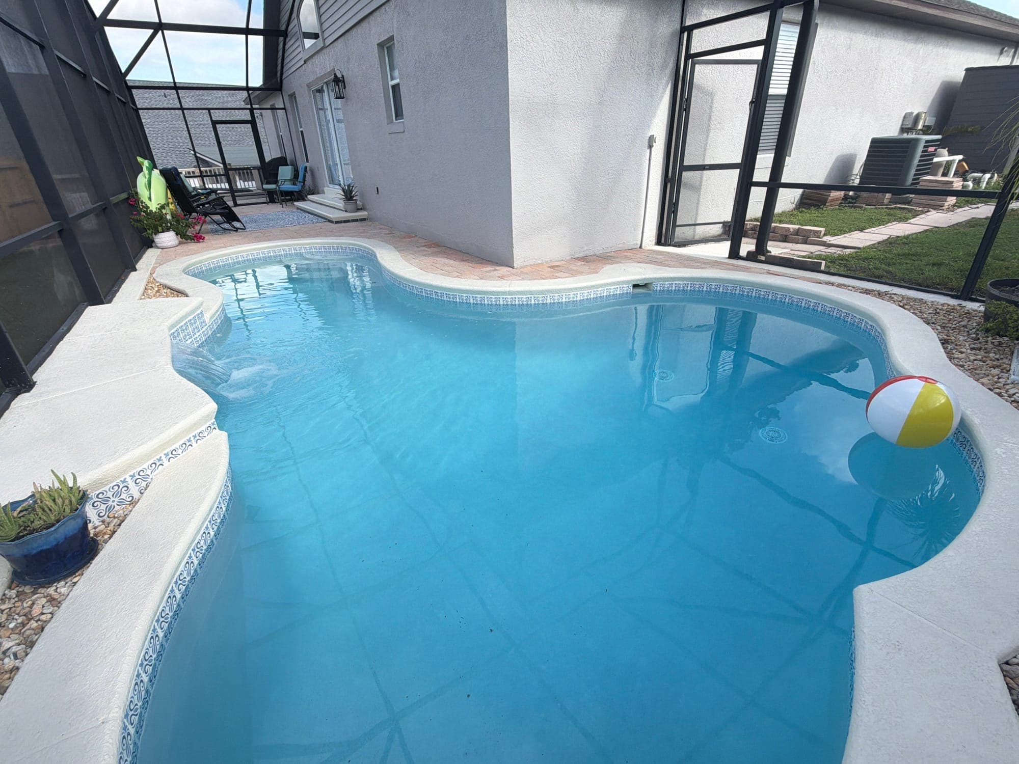 Piscina de forma libre bajo screen, con acabado azul claro y azulejo nuevo