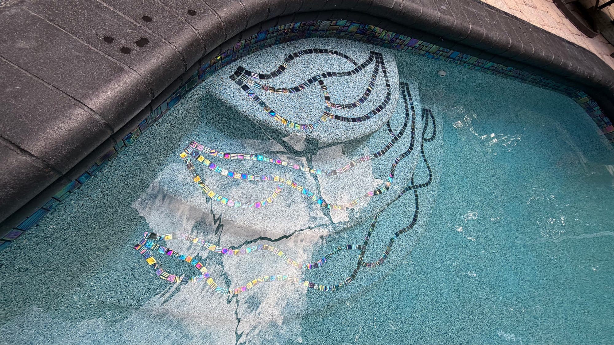 Diseño de mosaico en una banca de la piscina