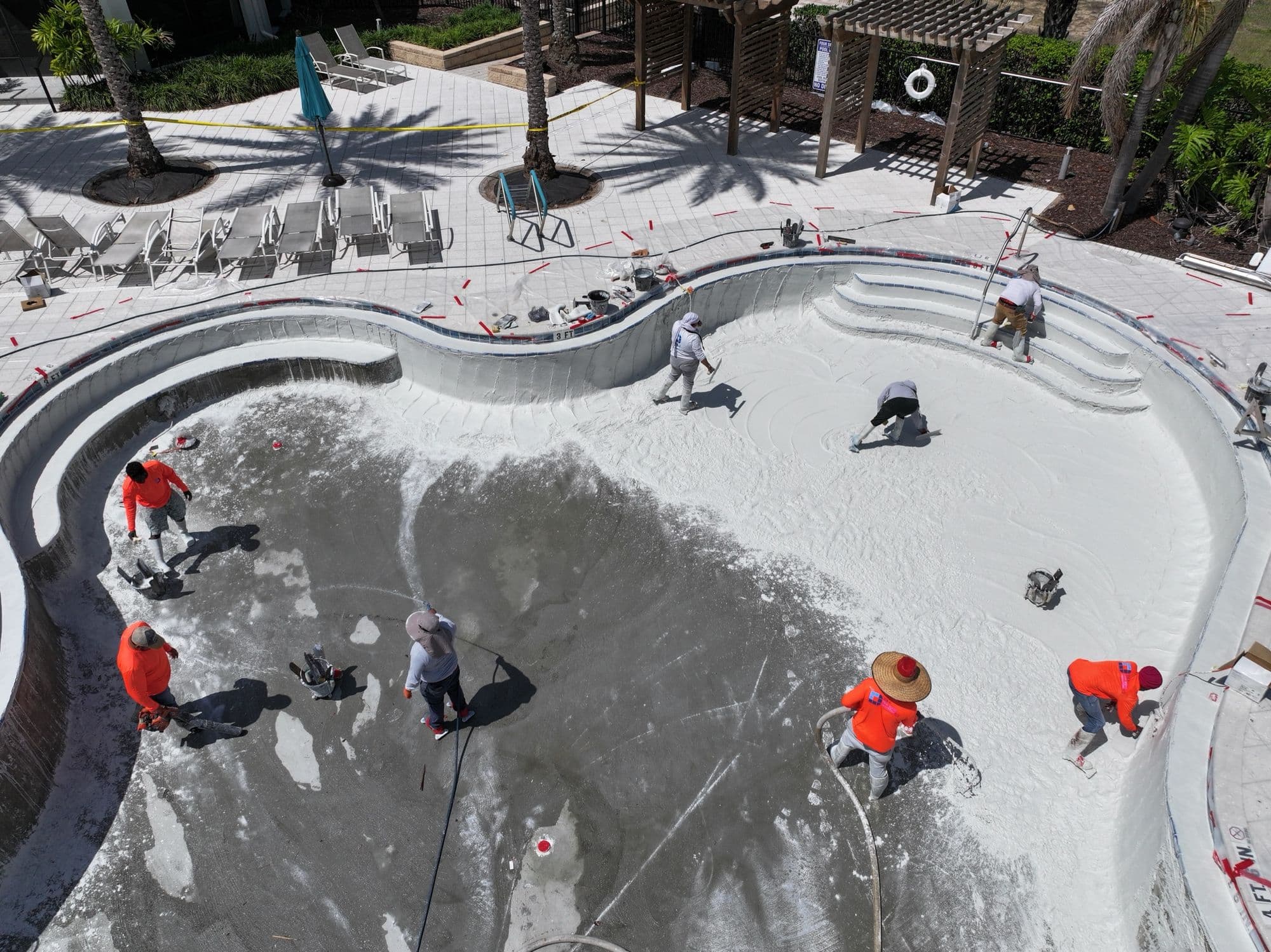 Equipo de D&J aplicando un acabado nuevo en la piscina de un resort