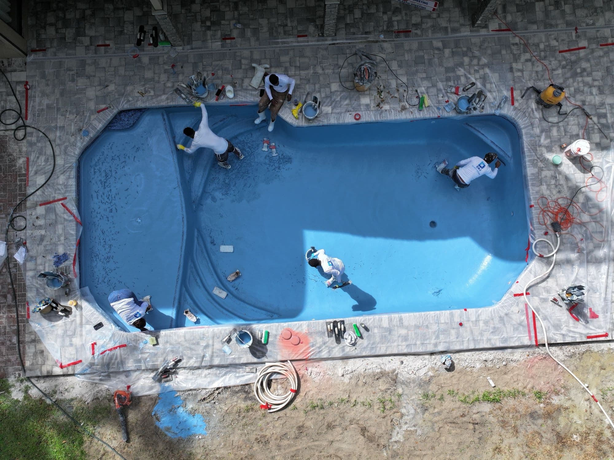El equipo de D&J con camisas de trabajo junto a una piscina