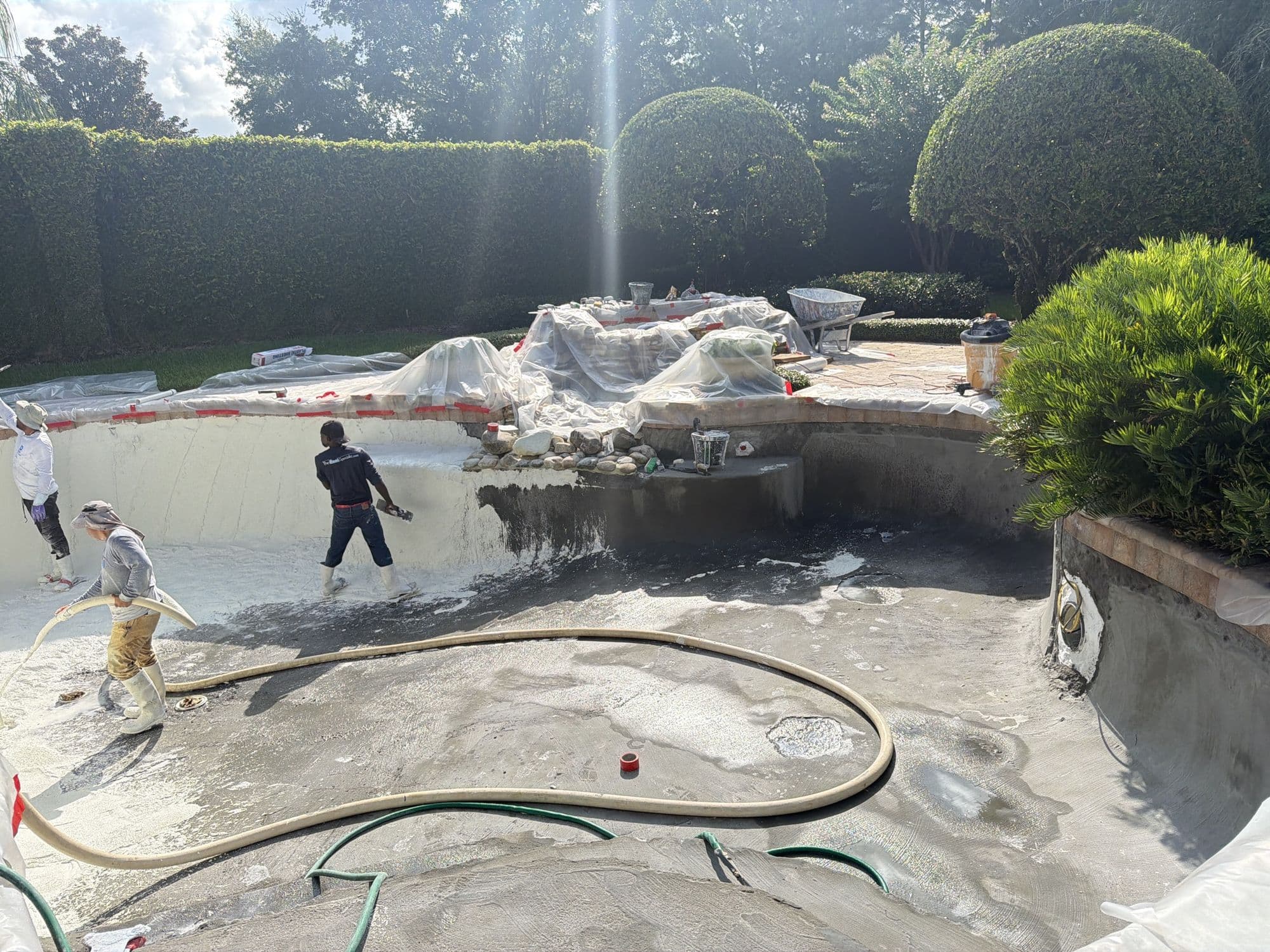 D&J crew working inside a drained pool