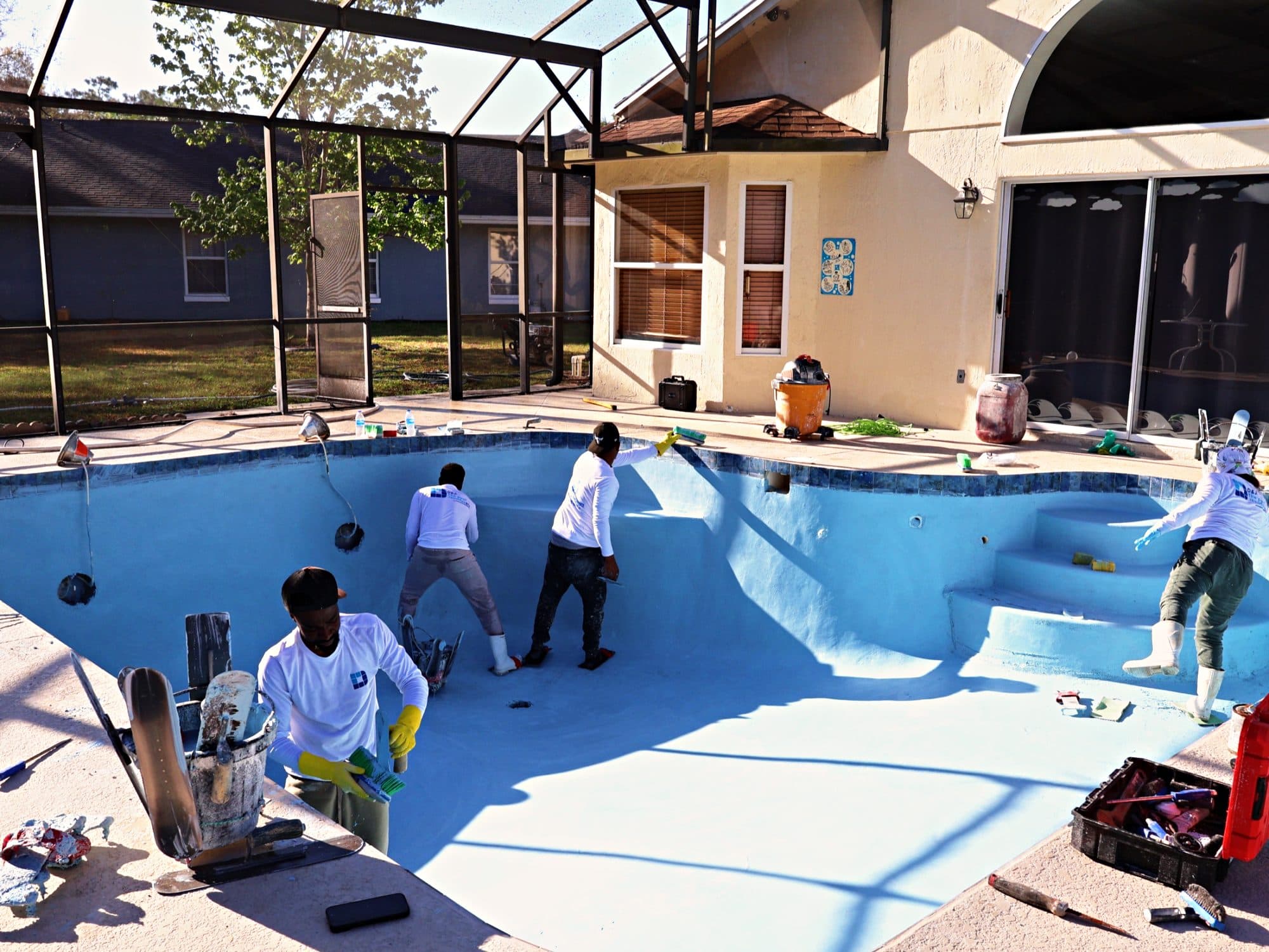 Crew on the steps and floor of a pool