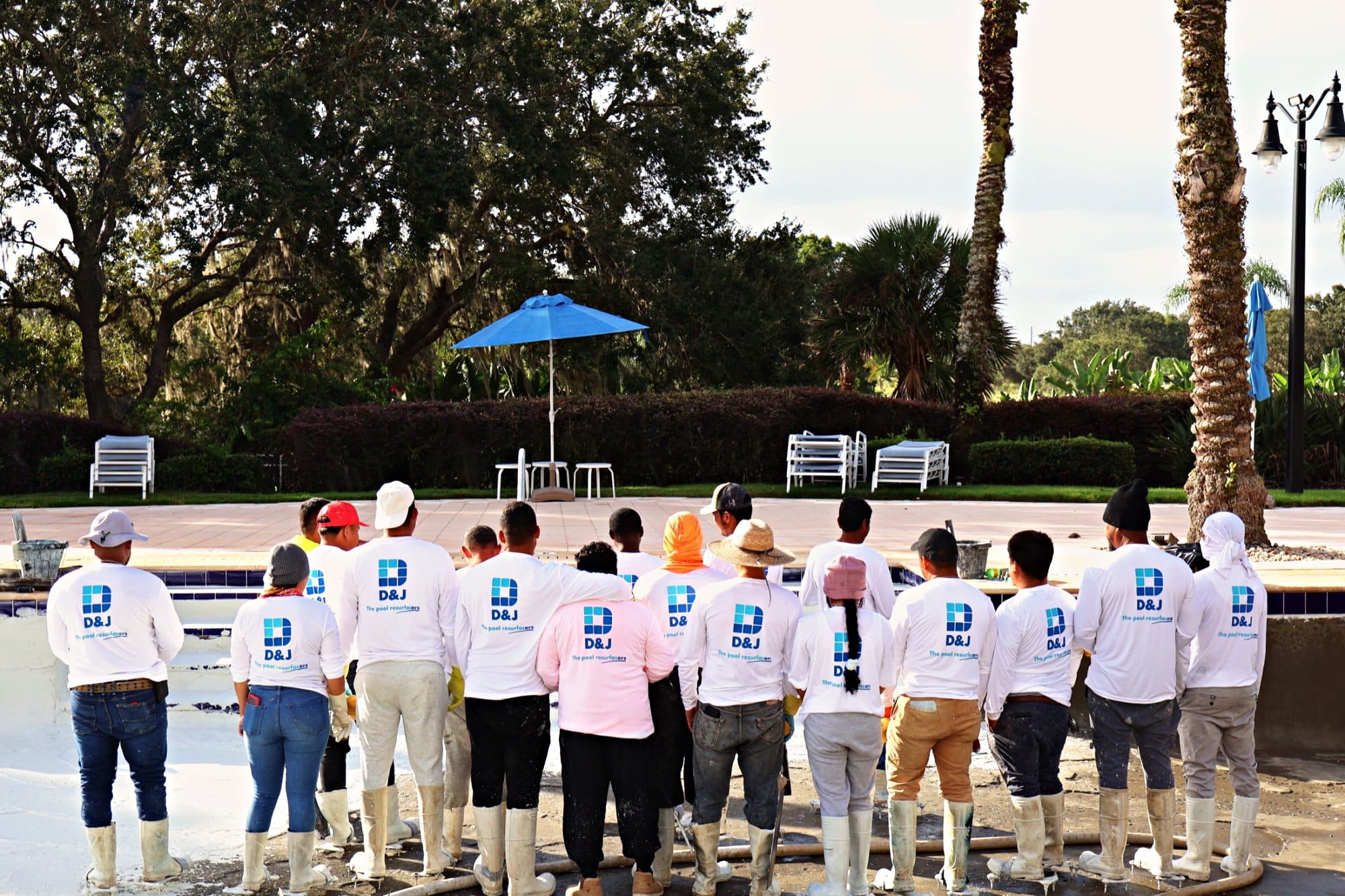 El equipo de D&J con camisas de la empresa junto a una piscina