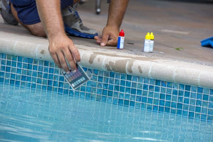 Pool testing kit being used in a swimming pool Pool testing kit being used in a swimming pool