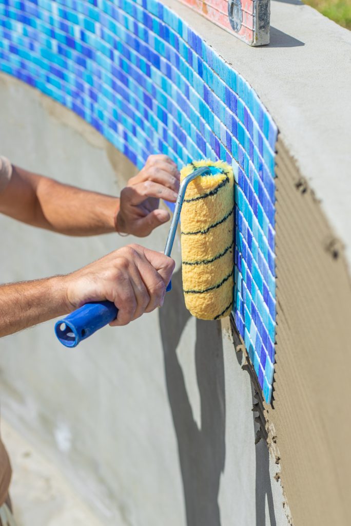 a man lays mosaic tiles in a swimming pool select 2026 03 25 23 25 32 utc pool resurfacing repair process — fixing pool surface damage Florida